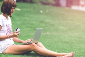 Açık havada dizüstü bilgisayardan internet alışverişi yapan kadın